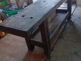 un banc en bois au milieu d'une pièce remplie de cartons