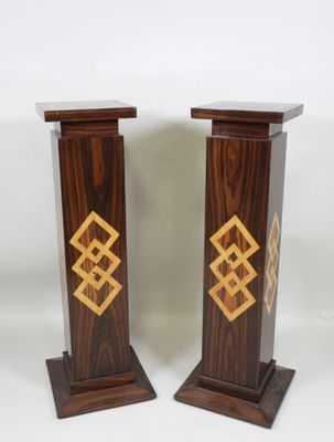 pair of wooden pedestals with gold and black designs on them