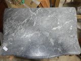 a black marble table top on a chair in a room