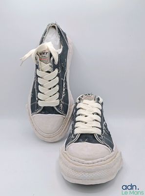une paire de baskets noires et blanches avec des lacets blancs sur fond blanc