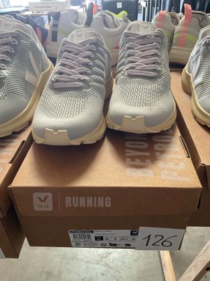 several pairs of running shoes are on a box in a store