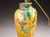 a yellow vase with a gold handle on a table