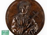 an image of a bronze plaque of a man holding a cross