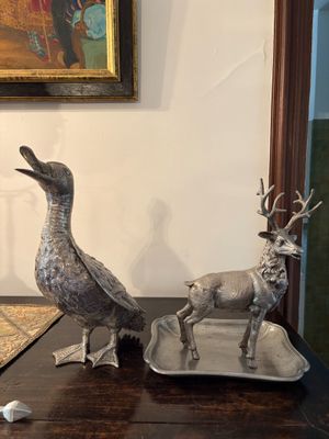 deux animaux en métal posés sur un plateau posé sur une table