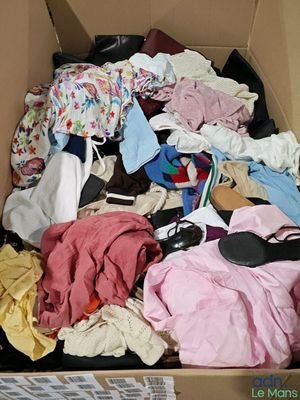 une boîte remplie de vêtements et de chaussures qui s'y trouvent