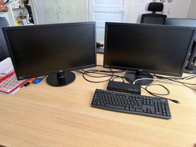deux écrans d'ordinateur et un clavier sur un bureau