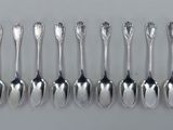 six cuillères en argent sont alignées sur une table