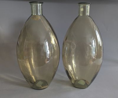 two glass vases sitting next to each other on a table