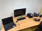 un bureau sur lequel se trouvent un ordinateur portable, un téléphone et d'autres appareils électroniques