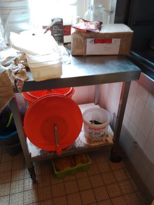 une table en métal sur laquelle sont posés deux seaux, dans une cuisine