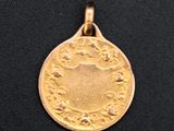 a close up of a gold coin on a black surface
