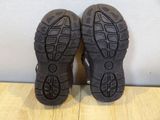 the soles of a pair of black hiking shoes on a wooden floor
