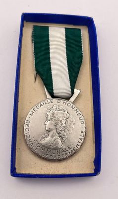 silver medal with green and white ribbon in a blue box
