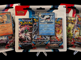 three packs of pokemon trading cards on display in a display case