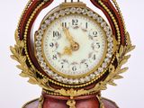 a clock that is sitting on a stand with a chain around it