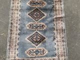 a blue and beige rug with a diamond design on it