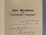 un livre ouvert, sur lequel figure un titre écrit à la main, posé sur une table