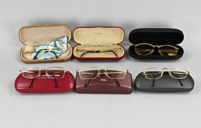 six paires de lunettes dans un étui posé sur une surface blanche