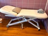 une table de massage recouverte d'une serviette, dans une pièce