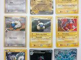 Des cartes Pokémon sont alignées sur une surface blanche