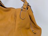 an image of a brown purse with a strap on it