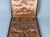 six pairs of scissors in a case on a blue surface