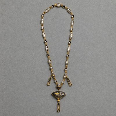 a gold and pearl necklace with a cross pendant