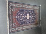 tapis accroché au mur dans une pièce où se trouve une tenture murale