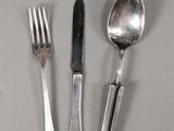 three forks and two spoons on a table