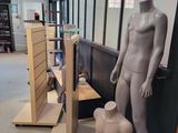 a mannequin and a teddy bear on display in a store