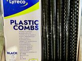a box of black plastic combs sitting on a counter