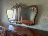 une commode en bois surmontée d'un miroir