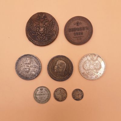 Plusieurs pièces sont disposées en cercle sur une surface beige.