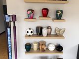 de nombreux vases différents sur les étagères de cette pièce