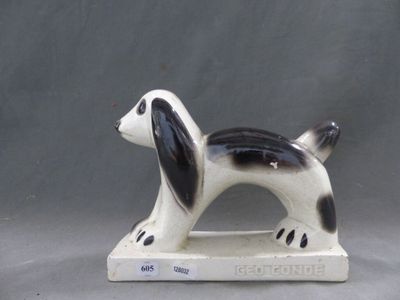 une figurine de chien en noir et blanc posée sur un socle blanc