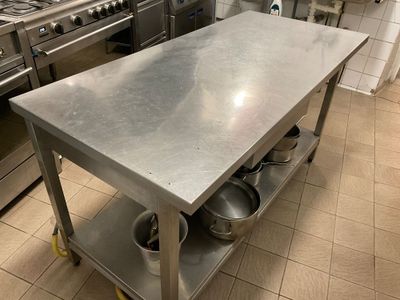 a stainless steel kitchen island with pots and pans on it