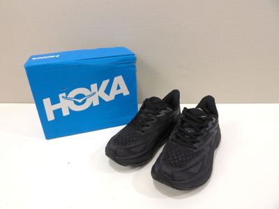 des baskets Nike Air Max noires devant une boîte bleue