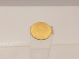 une pièce d'or posée sur un socle transparent