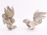 paire de figurines de coqs plaquées argent sur fond blanc