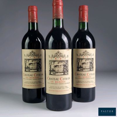 three bottles of red wine are lined up on a table