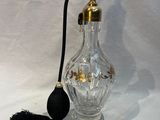 une bouteille en verre munie d'une poignée noire et d'un pompon