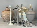 trois lampes posées sur une table à côté d'un vase