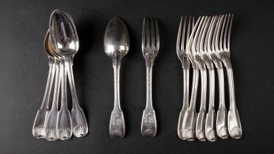 a set of five silverplated forks and spoons on a black background