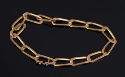 a close up of a gold chain bracelet on a black surface
