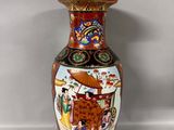 a vase with a painting on it sitting on a table