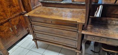 a wooden desk with a mirror on it in the corner of a room