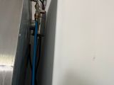 a blue hose attached to the side of a wall