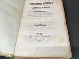 Quelqu'un tient un livre ouvert sur une table, sur fond noir.