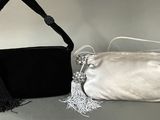 a black and silver purse and a silver purse on a table