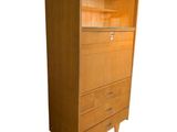 an image of a tall wooden cabinet with drawers
